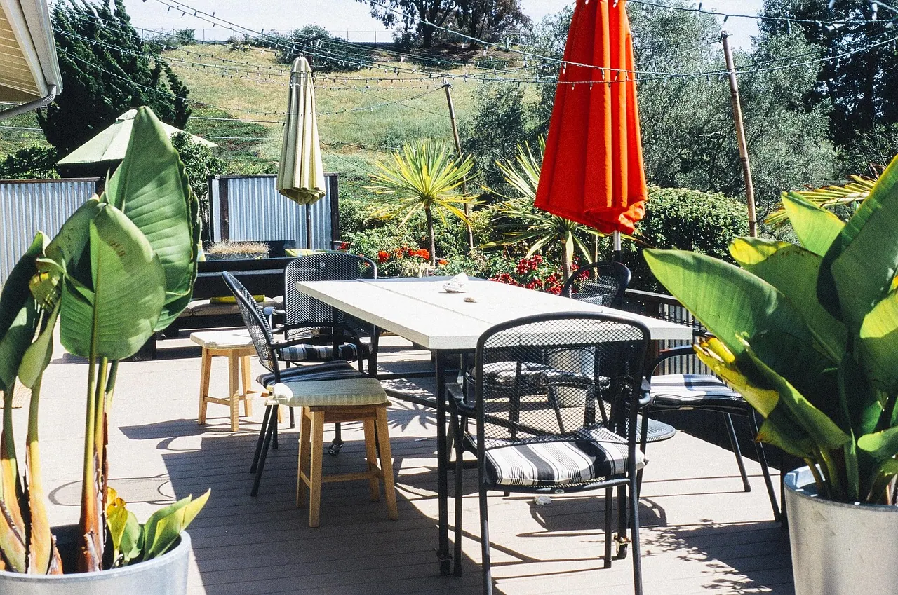 garden, porch, table furniture, chairs, home, house, summer, yard, exterior, patio, furniture, umbrellas, tables, plants, wood, deck, backyard, outdoors, sunny, string lights, porc