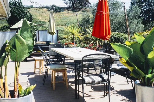 garden, porch, table furniture, chairs, home, house, summer, yard, exterior, patio, furniture, umbrellas, tables, plants, wood, deck, backyard, outdoors, sunny, string lights, porc