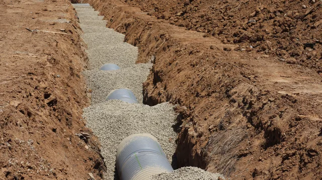 Detailed view of drainage pipe construction in a trench, Elk Grove, California. Patio budget reserve: four unknowns that decide it